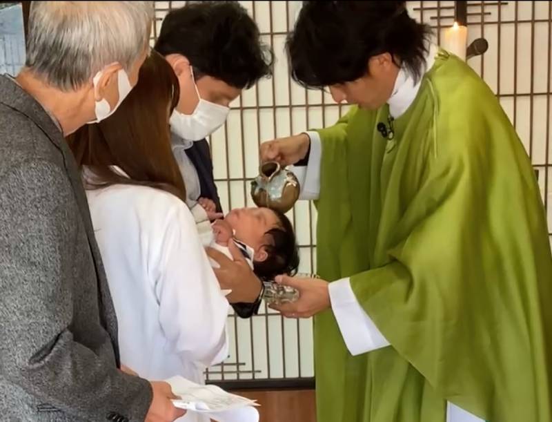 Picture of a baby being baptized by the priest of Takeo Catholic Church